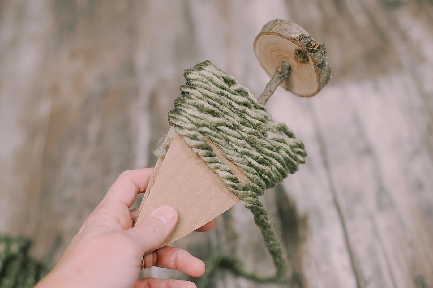 hot glue yarn to the bottom of the cardboard pieces to make a yarn wrapped cardboard tree