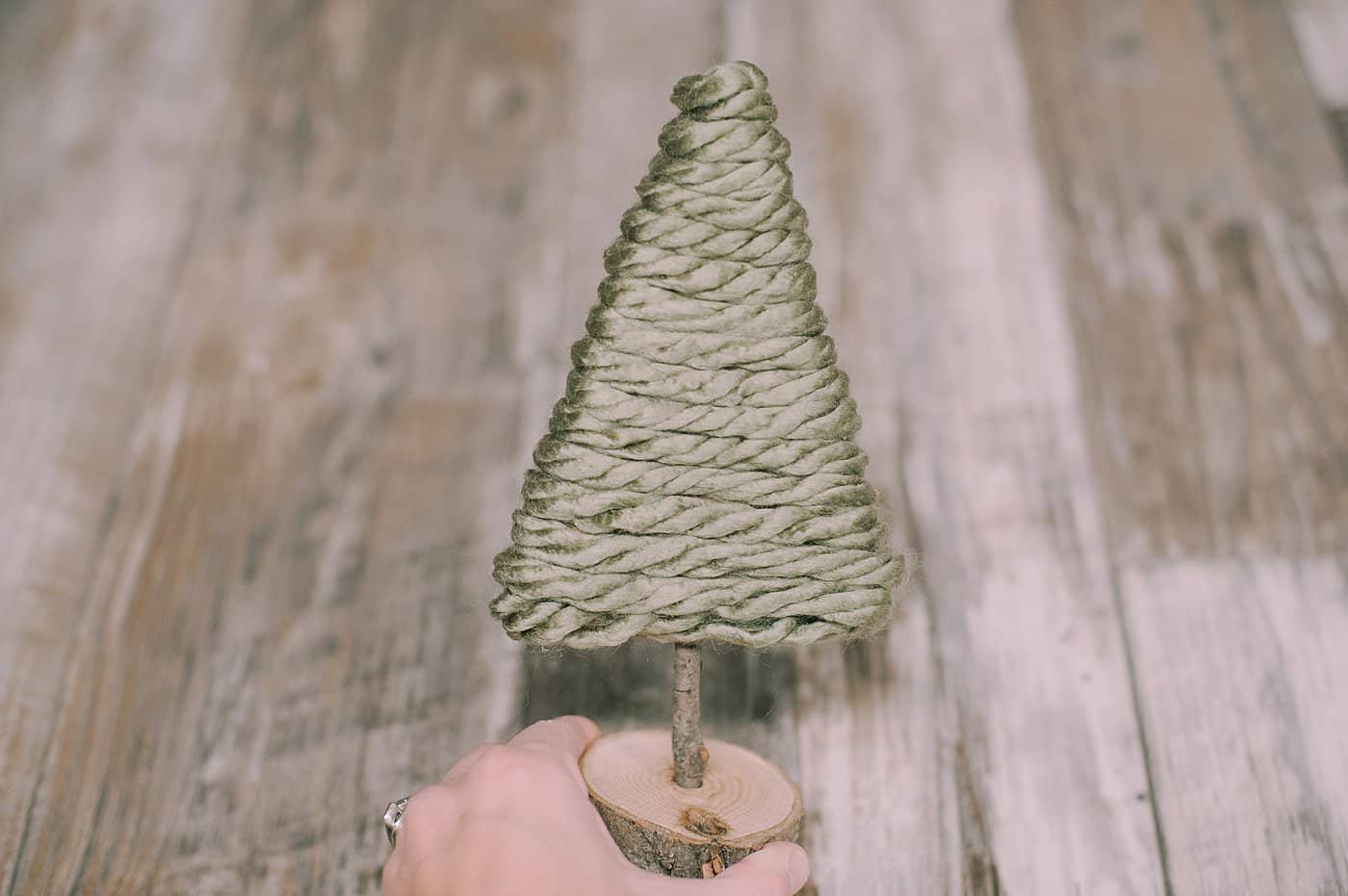 hot glue yarn to the bottom of the cardboard pieces to make a yarn wrapped cardboard tree