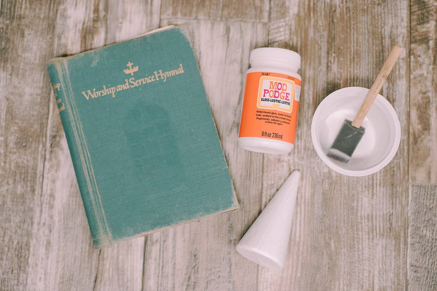 Supplies needed to make a Mod Podge Book Page Cone Tree.