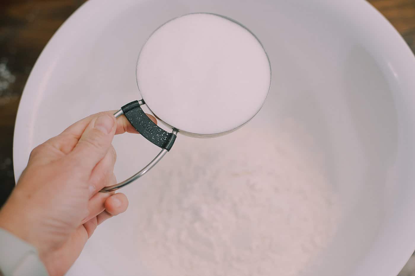 Add one cup of salt to the bowl containing two cups of flour.