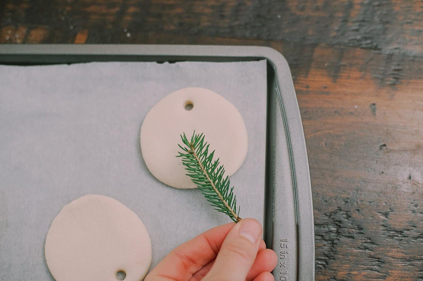 Press a pine branch into the salt dough ornament to add a pine impression.