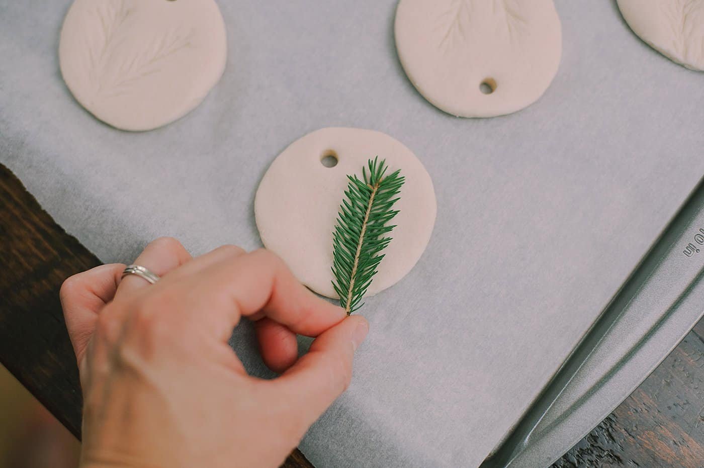 Press a pine branch into the salt dough ornament to add a pine impression.