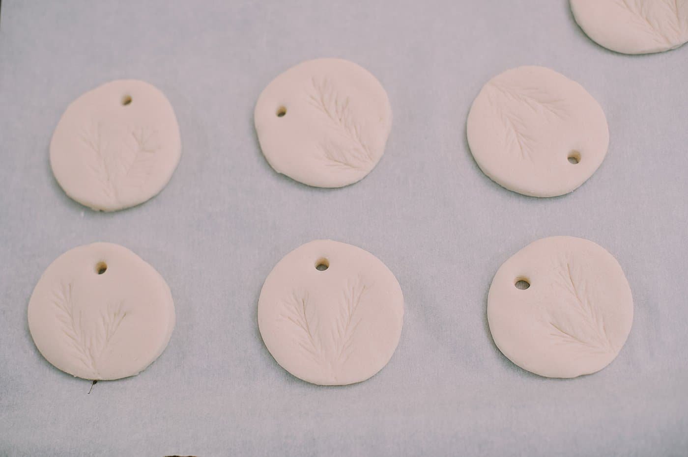 Press a pine branch into the salt dough ornament to add a pine impression.