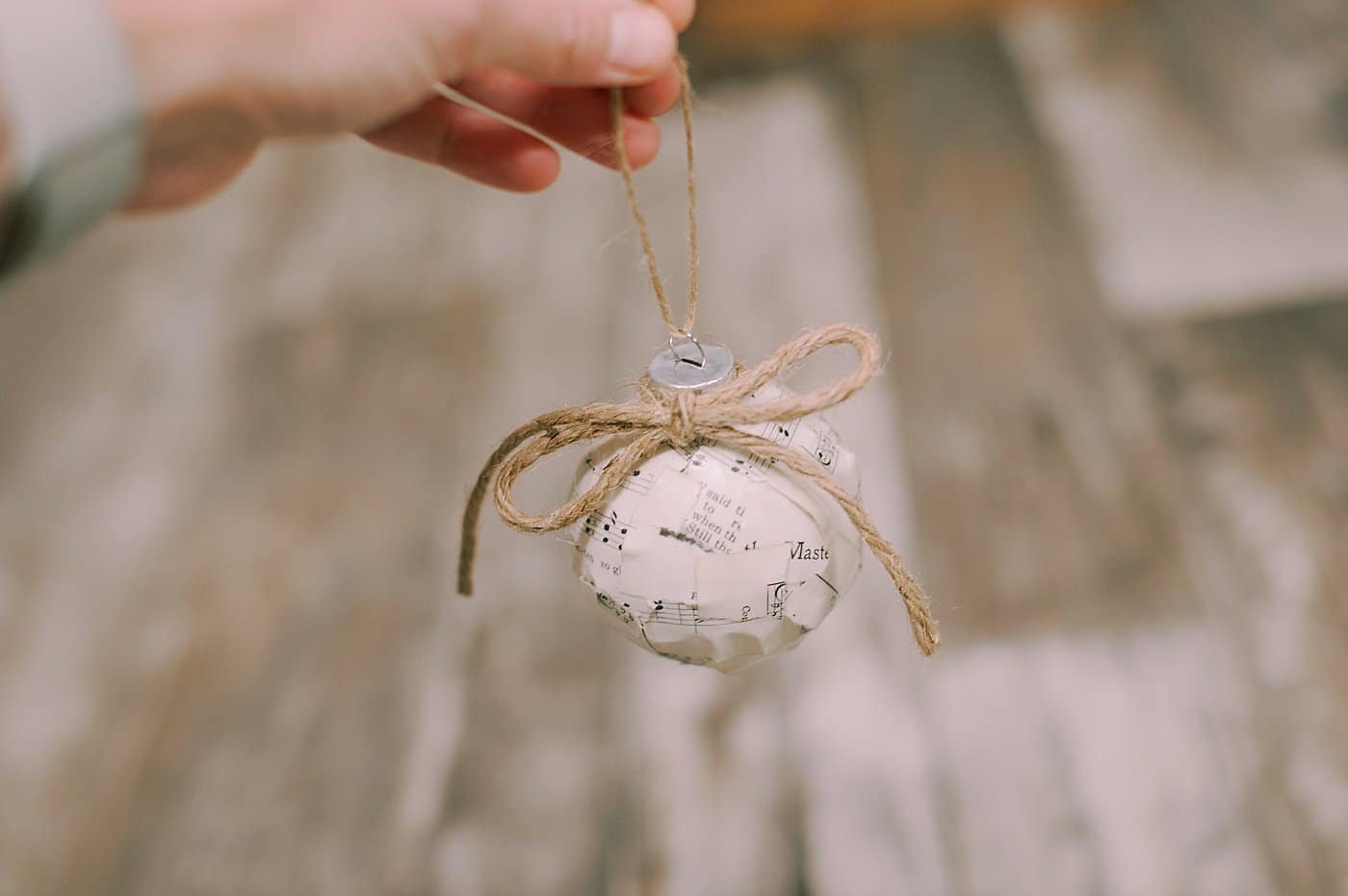 add a piece of twine around the neck of the ornament ball and tie a bow for decoration