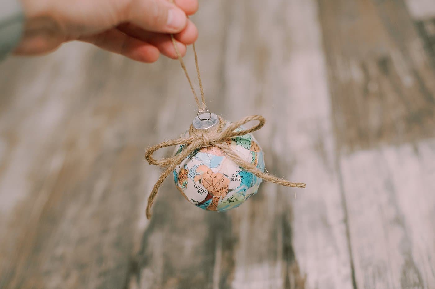 add a piece of twine around the neck of the ornament ball and tie a bow for decoration