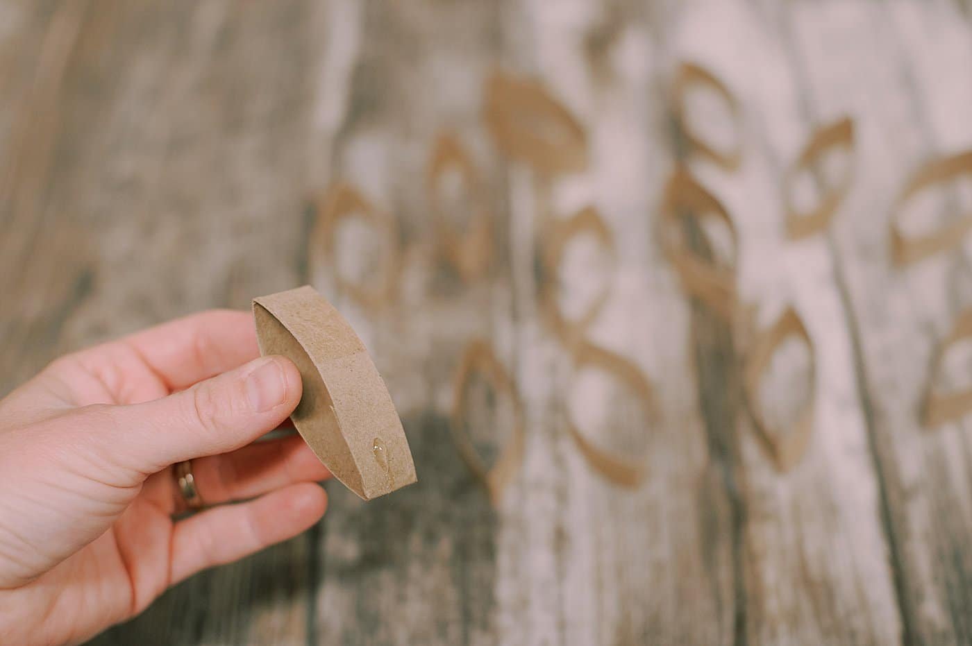 Put hot glue near the bottom of one section of the toilet paper cardboard tube.