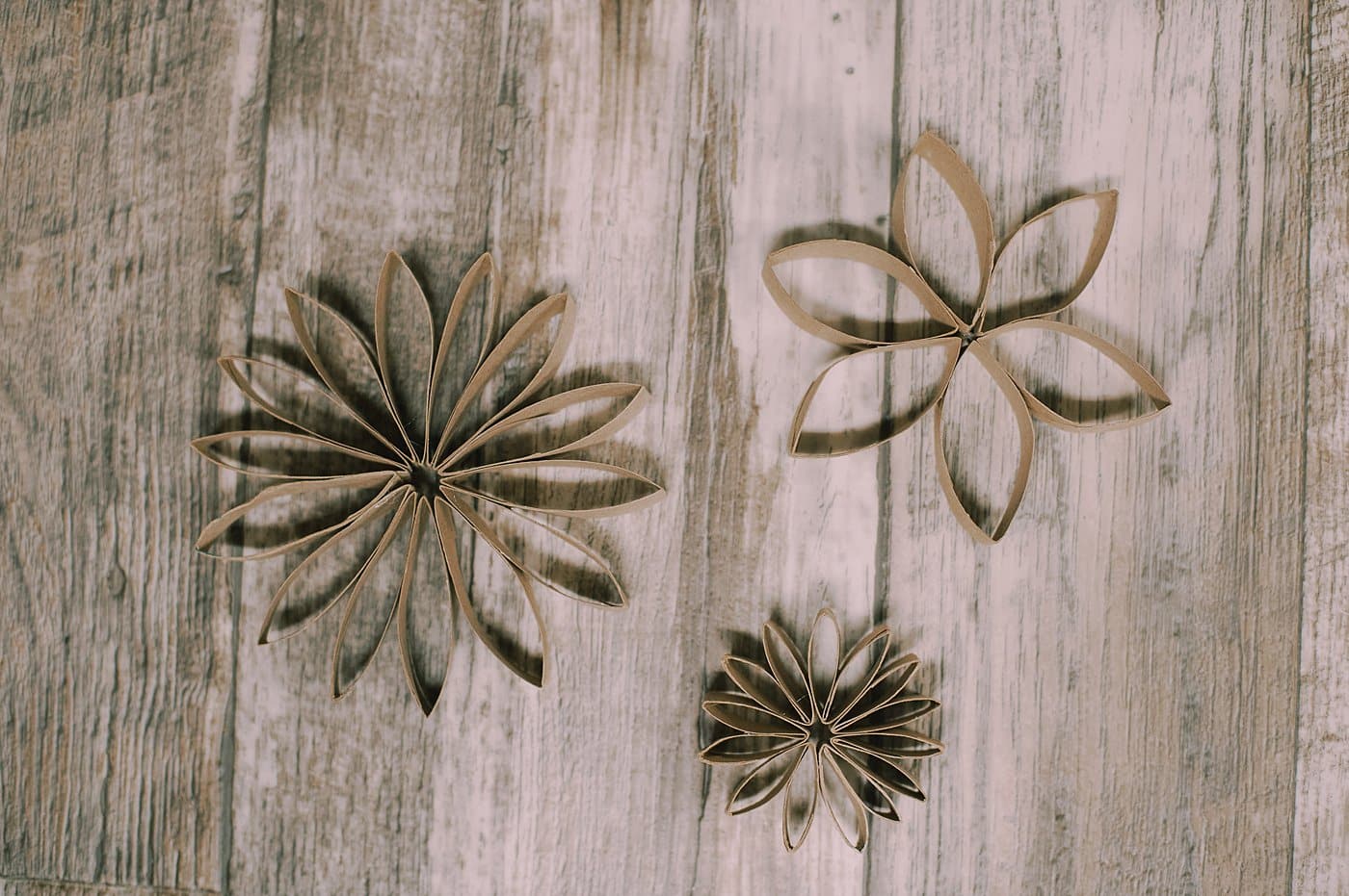 Three toilet paper flower ornaments.