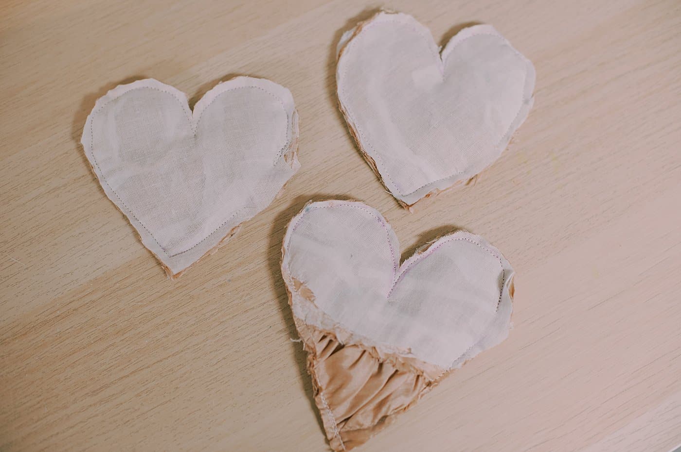 Hearts cut out of fabric to make memory ornaments.