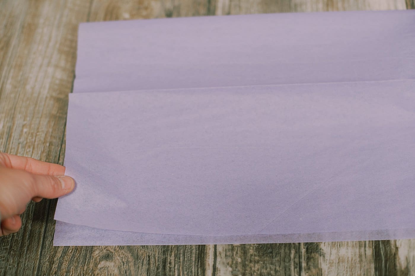 Fold a piece of tissue paper in half.