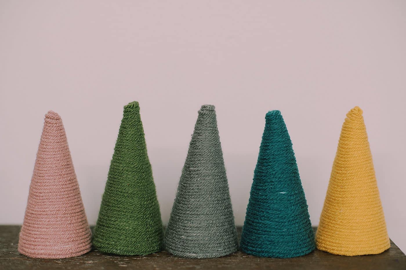 How to make yarn cone trees for Christmas by wrapping styrofoam cones with yarn.