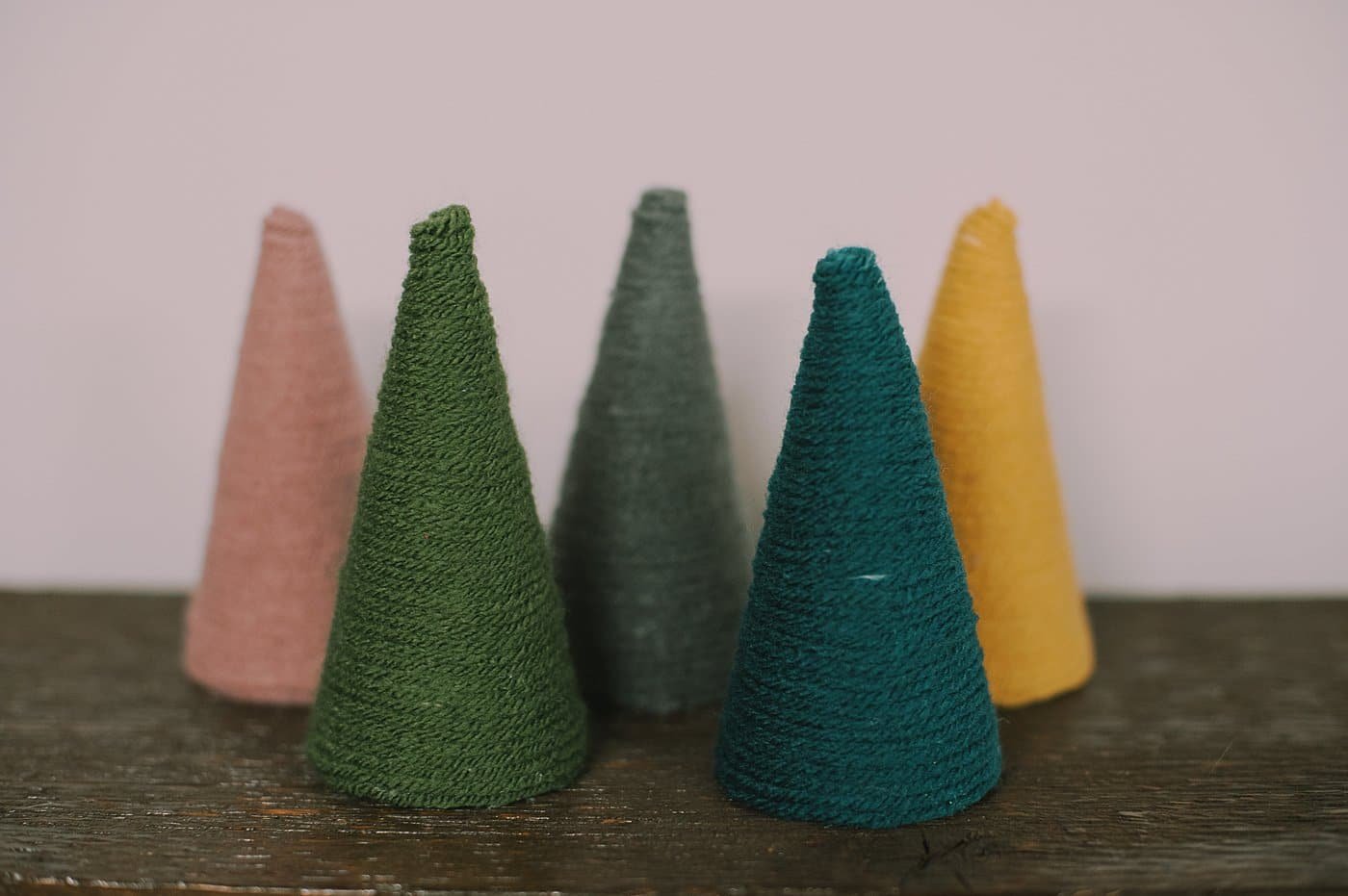 How to make yarn cone trees for Christmas by wrapping styrofoam cones with yarn.