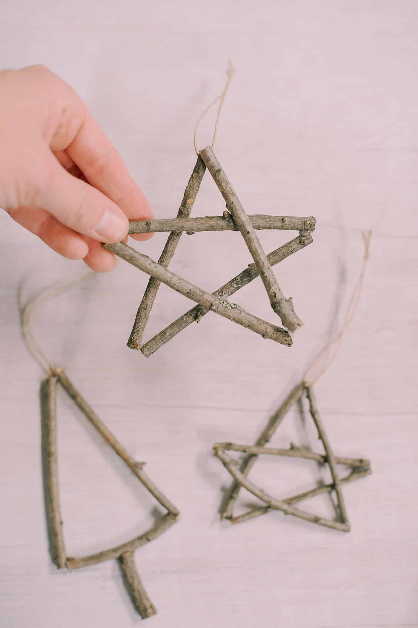 Ornaments made with sticks - a star shape and a Christmas Tree shape with twine hanging strings.