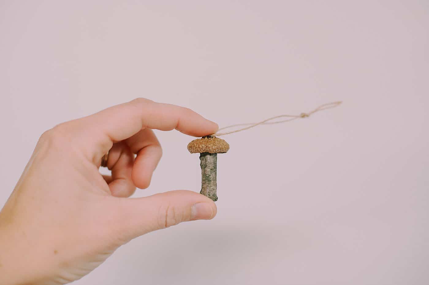 How to make tiny mushroom ornaments using sticks and acorn caps.