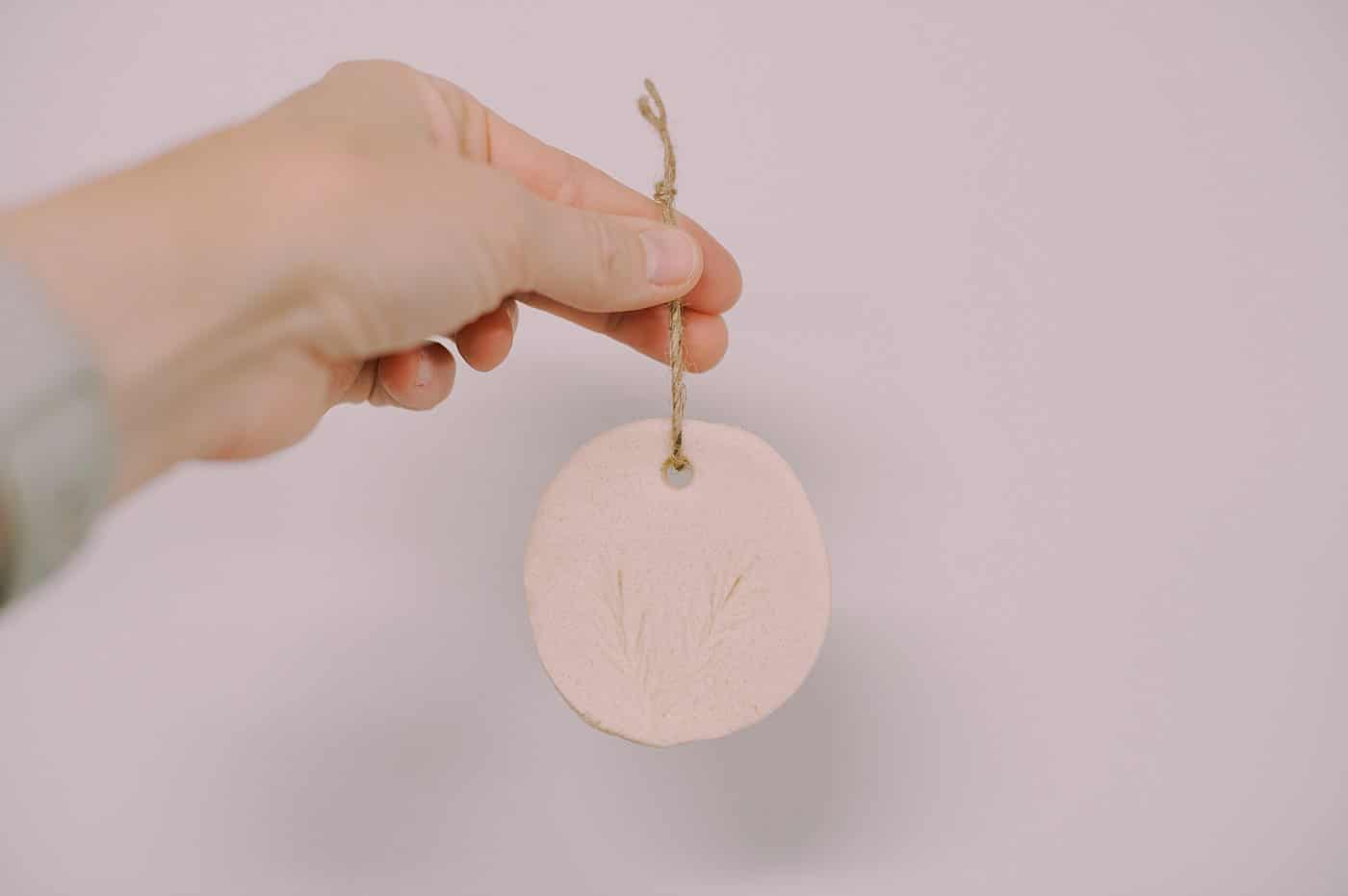 DIY salt dough ornaments with pine needles pressed into them for a pine design embellishment.