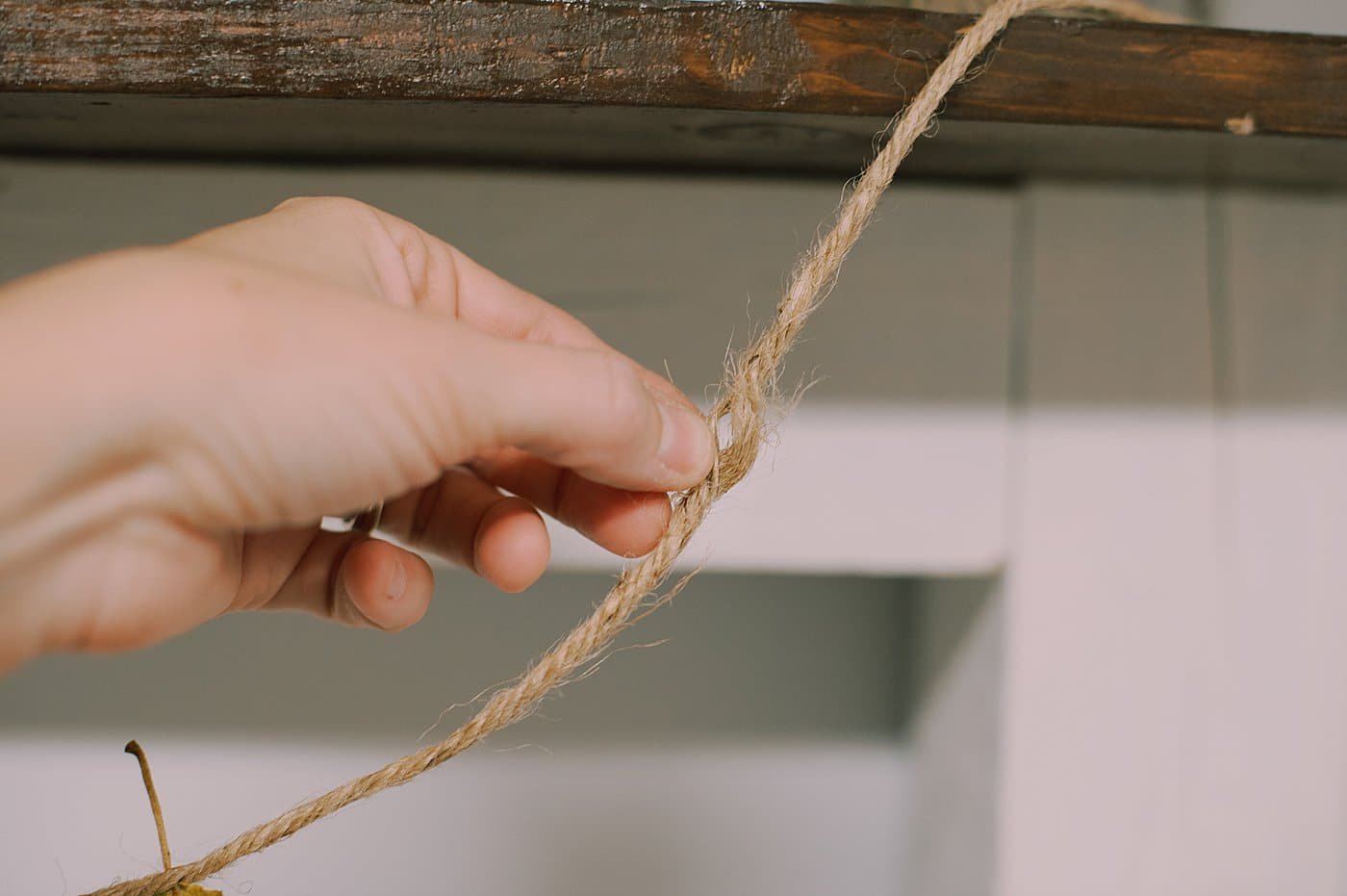 Spread the twine to make room to slide the stem of a leaf in.