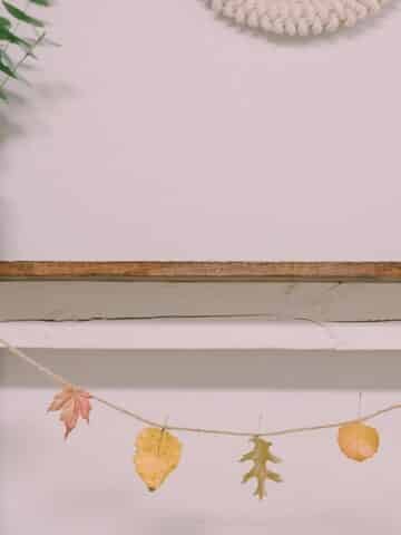 Learn how to make a beeswax leaf garland using colorful fall leaves that are dipped in melted beeswax.