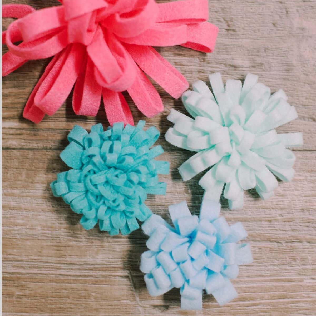 Colorful felt mums of different sizes and fringe thicknesses.